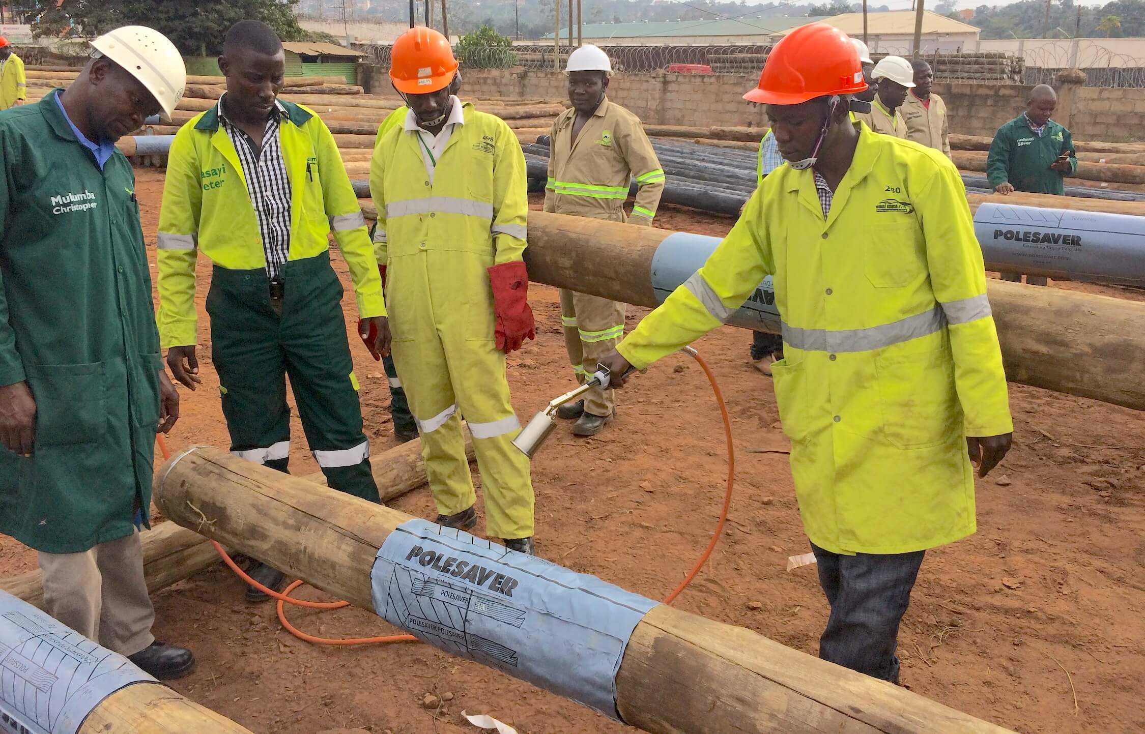 Umeme employees being trained to apply Polesaver Sleeves to wooden poles