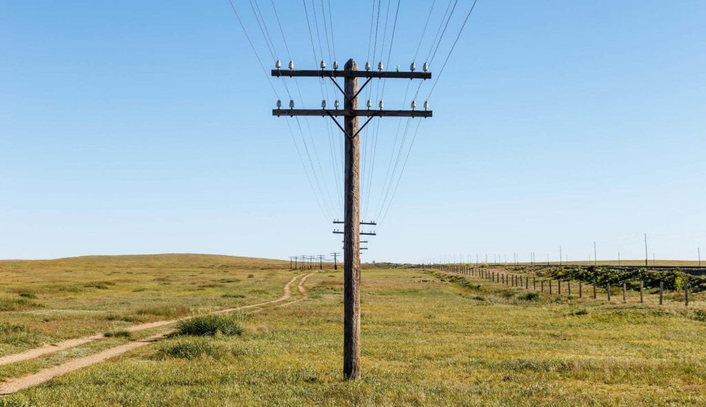 Utility Pole Materials: Which Is Best? - Hero Image of utility pole stood up in a field
