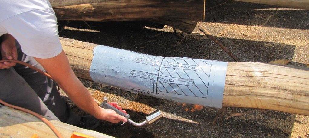 Polesaver sleeve being applied to a chestnut utility pole in Slovenia