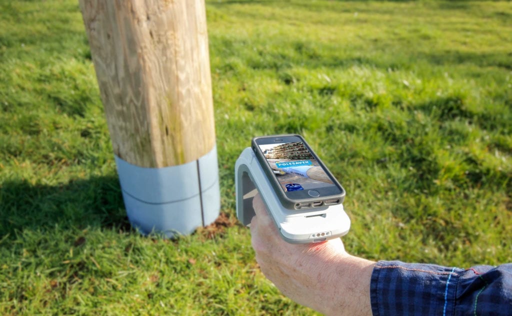 Polesaver RFID Asset Tracking Image Showing Smartphone attached to RFID reader pointed at a wooden utility pole with a polesaver sleeve on