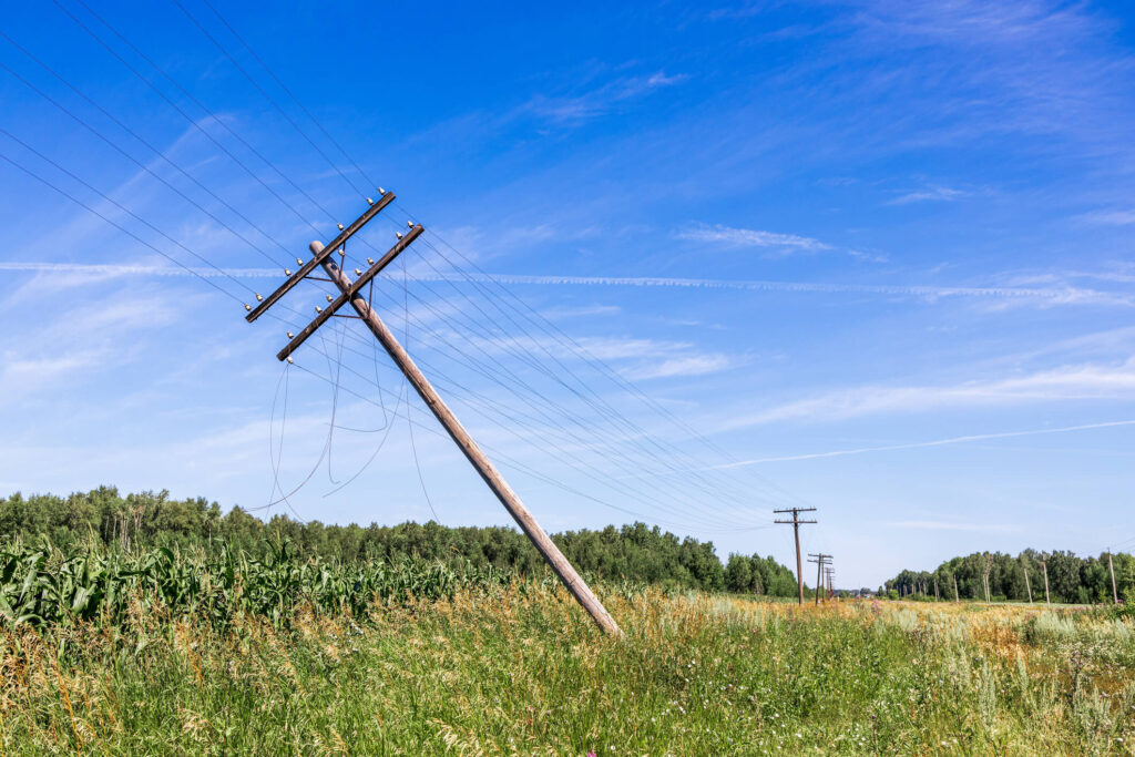 unstable electricity pole falling in a field